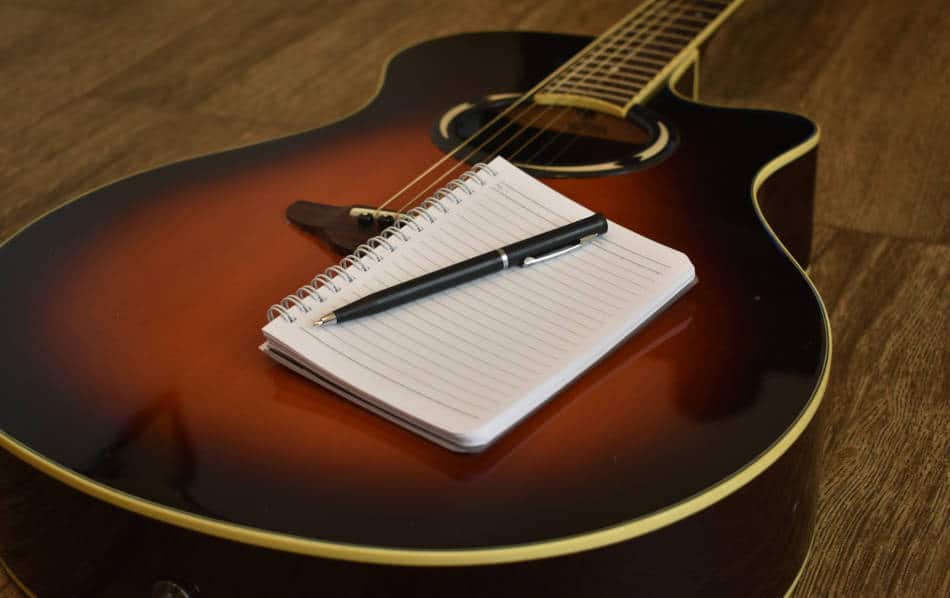 Guitar and notebook for songwriting